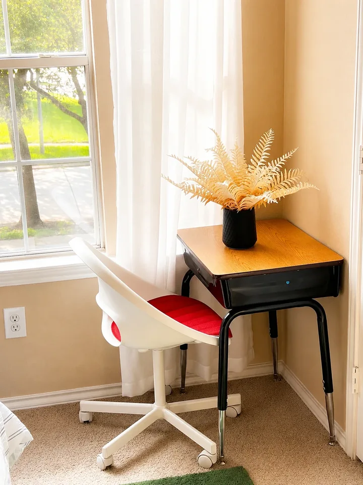 A dedicated desk by a bright window in Designer Loft