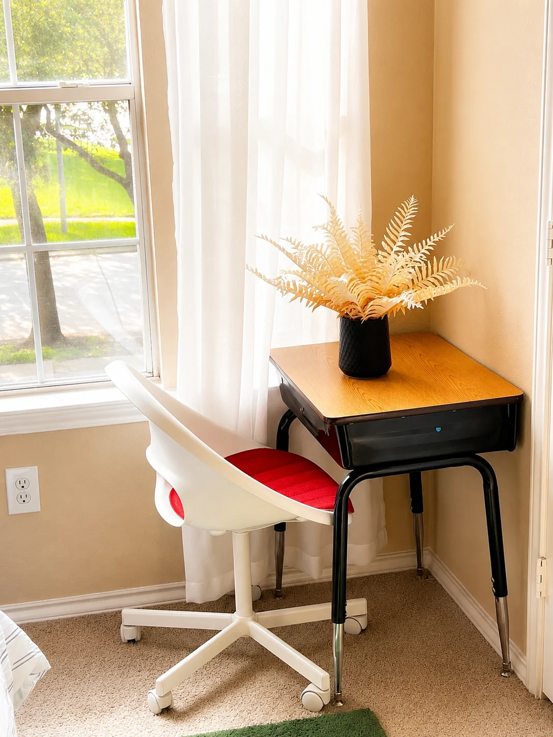 A sunny workspace at UPREST with a wooden desk and red-cushioned chair