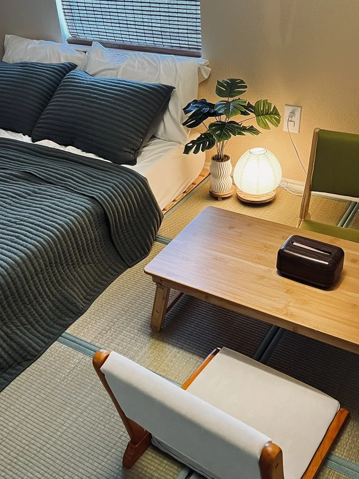 Warm bedside lighting and a small reading table